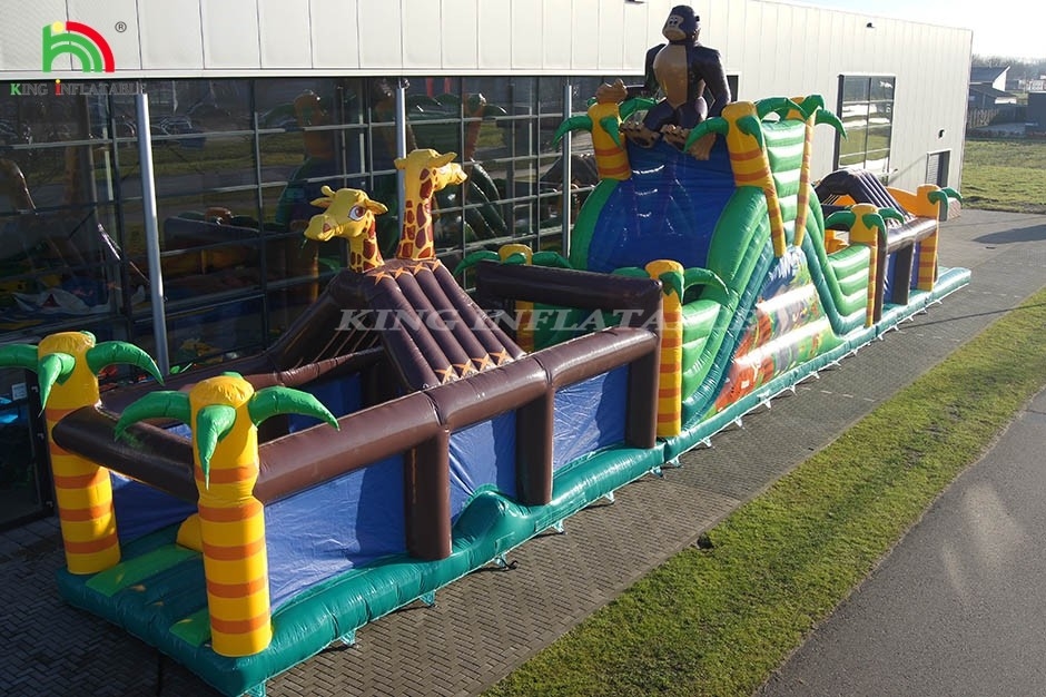 Gran campo de obstáculos inflables al aire libre con tobogán y cerca saltando salto juego de deportes con trampolín y tobogán